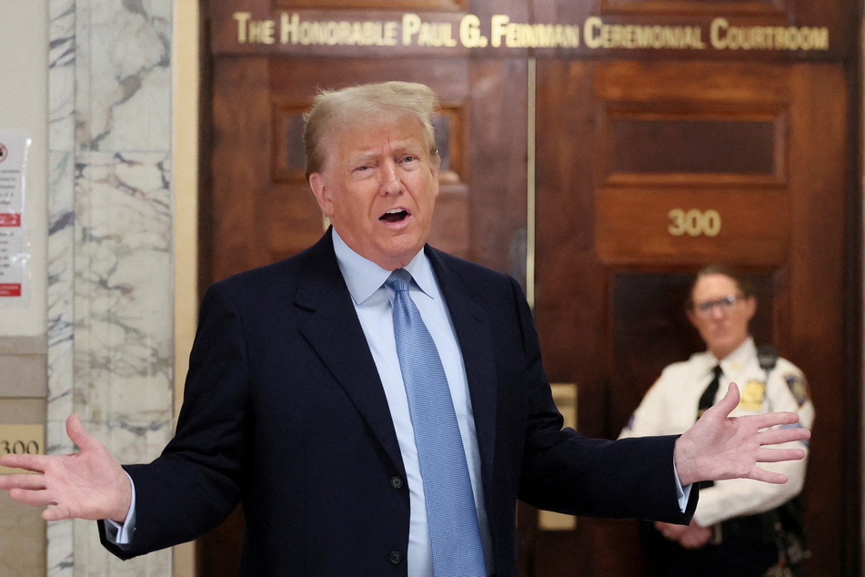 Former president Donald Trump speaks in the hallway as he attends his Manhattan courthouse trial in a civil fraud case in New York.