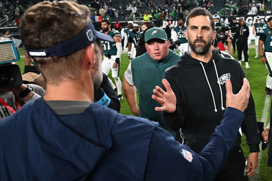Philadelphia Eagles head coach Nick Sirianni (r.) greets Dallas Cowboys head coach Brian Schottenheimer (l.) on the field after the game at Lincoln Financial Field.