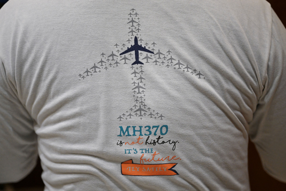 Jiang Hui, whose mother was on board the missing Malaysia Airlines flight MH370, is seen wearing a t-shirt commemorating the accident at his home in Beijing.