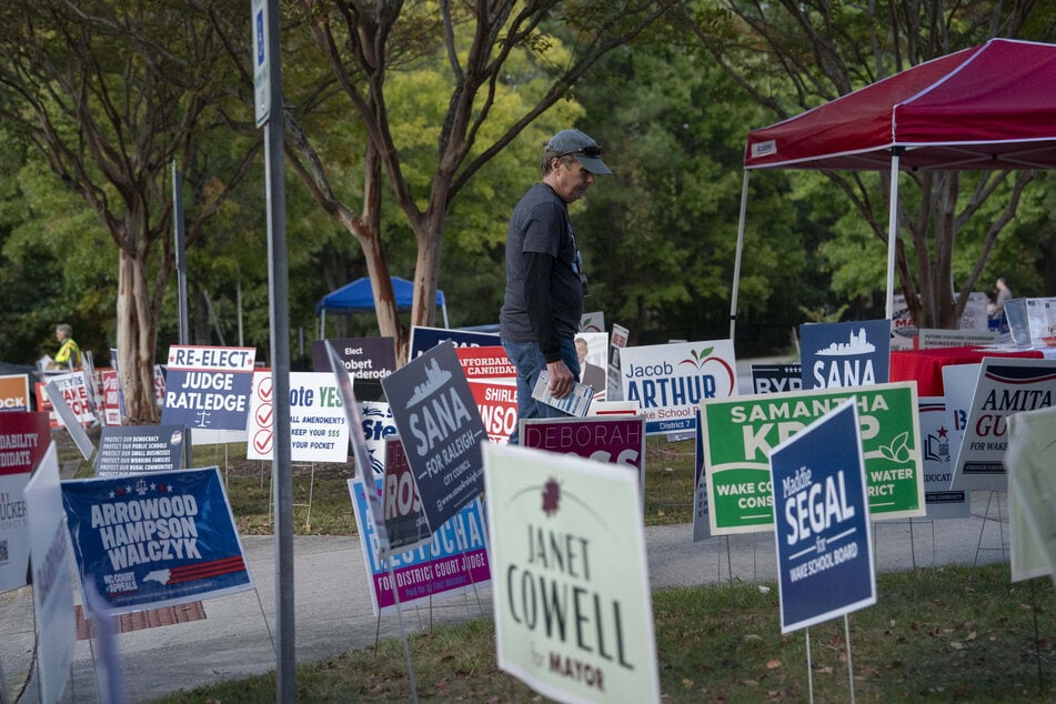 A volunteer walks past signage during early voting for the midterm elections on October 25 in Cary, North Carolina. Aggressive attack ads and political mudslinging have voters feeling some serious midterm fatigue.