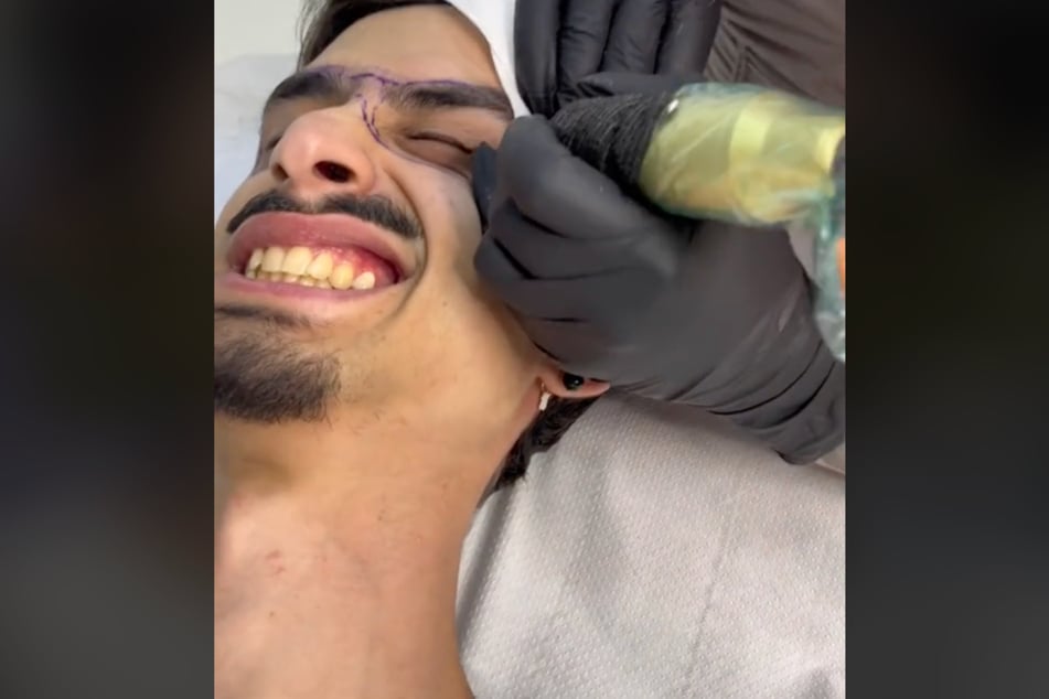 Tattoo artist Maria Gina Altobelli appears to ink the glasses frames on the customer's face.