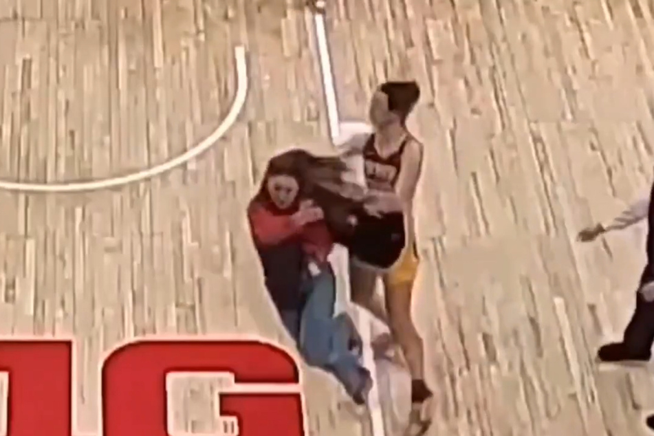 Caitlin Clark (r) is facing criticism from fans for what is being described as a dramatic sympathy flop after colliding with a fan following the loss to Ohio State.