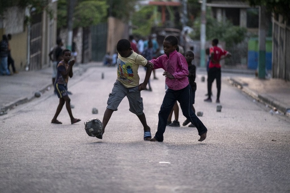 Haitian children play soccer in the street in Port-au-Prince.