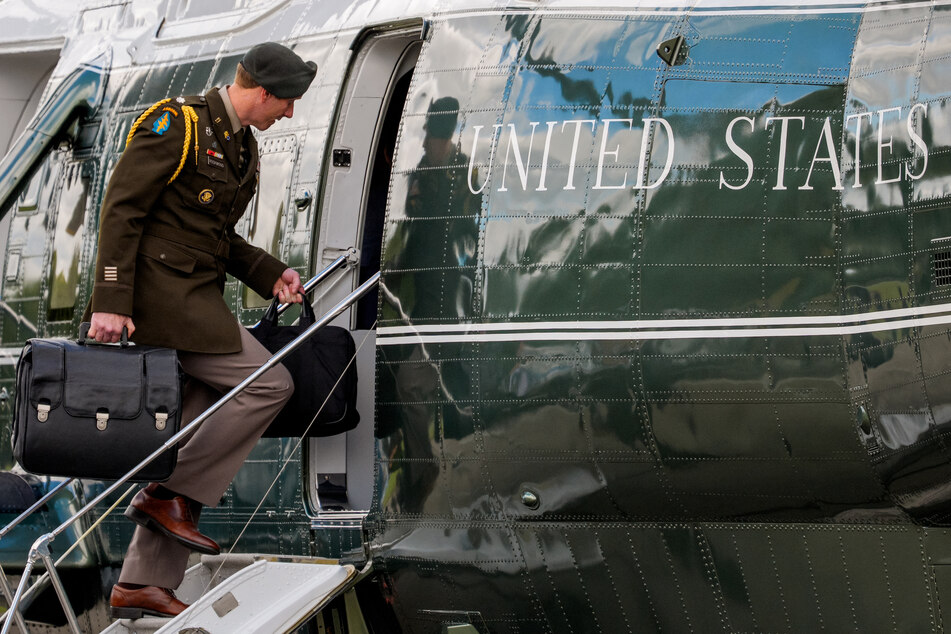A military aide carries the "nuclear football," which contains launch codes for nuclear weapons as he boards Marine One to join President Donald Trump on October 10, 2025.