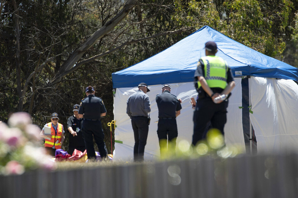 Officers inspect the jumping castle at Hillcrest Primary School in Devonport, Australia, after a freak accident turned deadly.