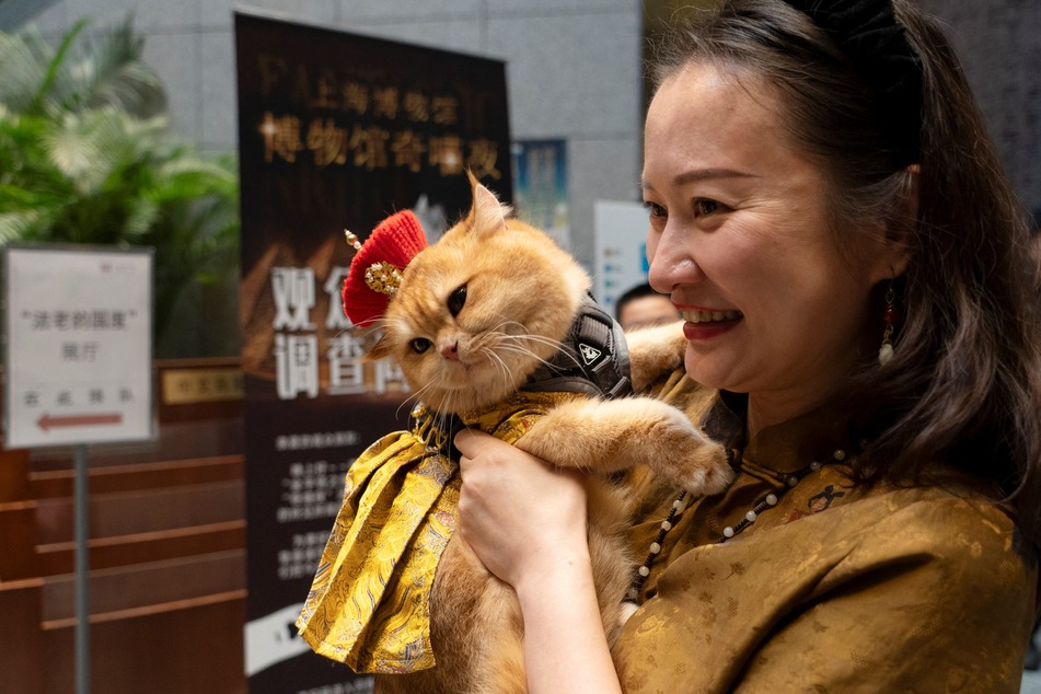 Cat owner Amy carries her cat named "Trump" while attending cat night at the Shanghai Museum in Shanghai on Saturday, July 27, 2024.