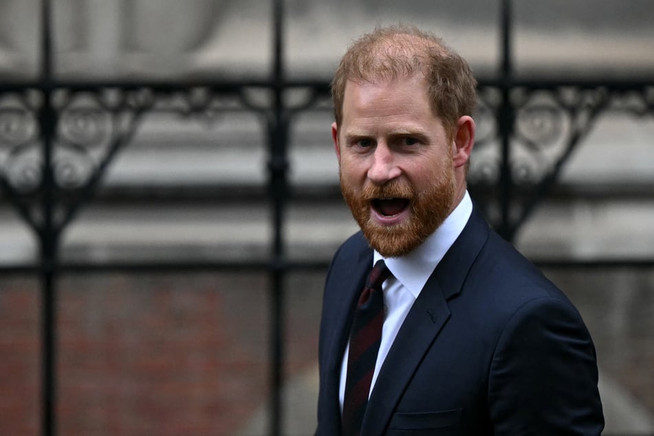 Prince Harry reacts to questions from journalists as he departs the High Court in London on January 21, 2026, following the third day of the trial in his case against a major UK newspaper group.