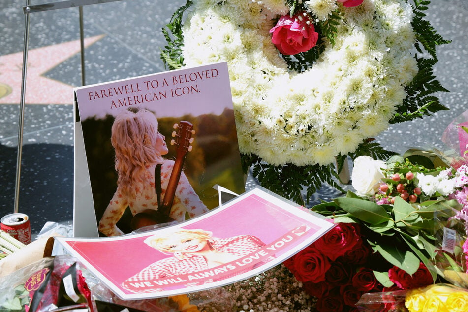 Flowers and remembrances are laid on Dolly Parton's Star on the Hollywood Walk of Fame on August 25. The country singer's legacy spanned beyond her hit music, as she also focused heavily on philanthropy.