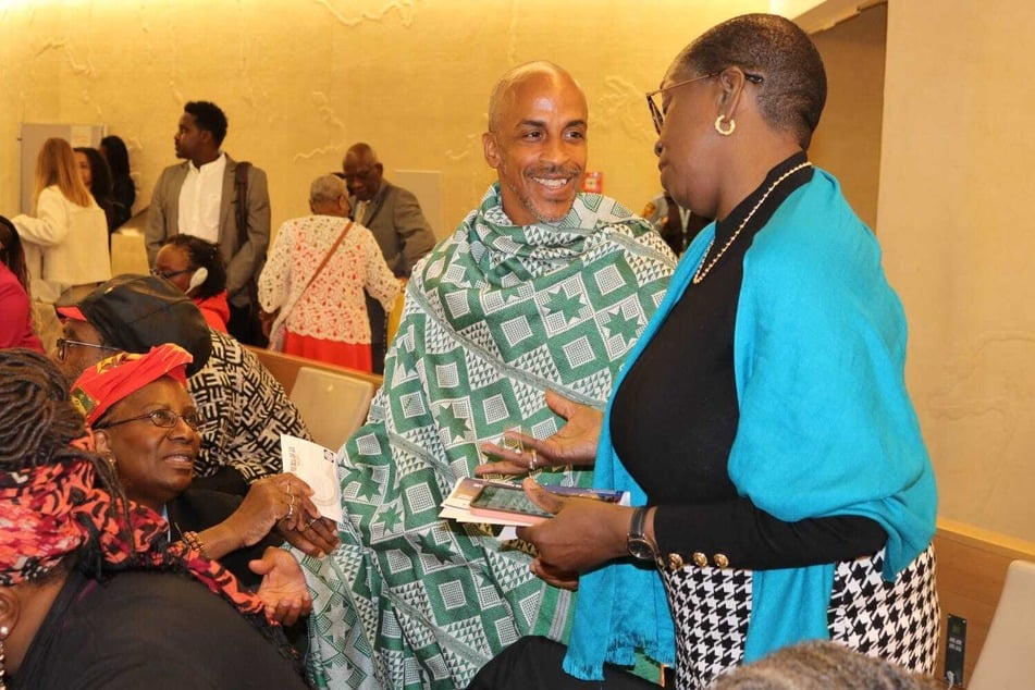 Siphiwe Baleka (c.) speaks with Enith Williams (r.) of the Reparations Finance Lab following his intervention before the United Nations Permanent Forum on People of African Descent.