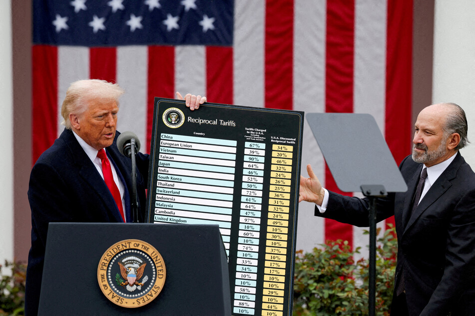 President Donald Trump (l.) holds a chart next to US Secretary of Commerce Howard Lutnick as he delivers remarks on tariffs in the Rose Garden of the White House on April 2, 2025.