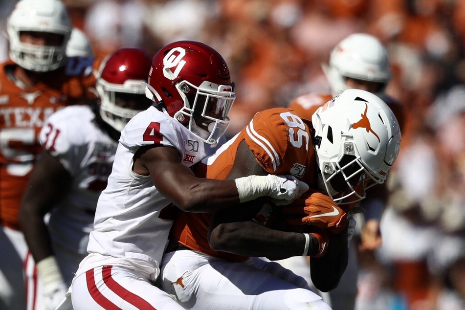 Malcolm Epps of the Texas Longhorns is tackled by Jaden Davis of the Oklahoma Sooners during the 2019 AT&T Red River Showdown at the Cotton Bowl.