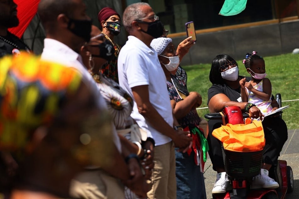 People listen to speakers during a rally for reparations at the African Burial Ground National Monument in New York City.