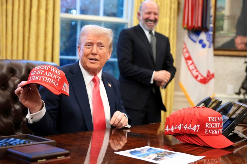 President Donald Trump holds up a hat stating "Trump Was Right About Everything" after signing executive orders in the Oval Office at the White House on February 25, 2025.