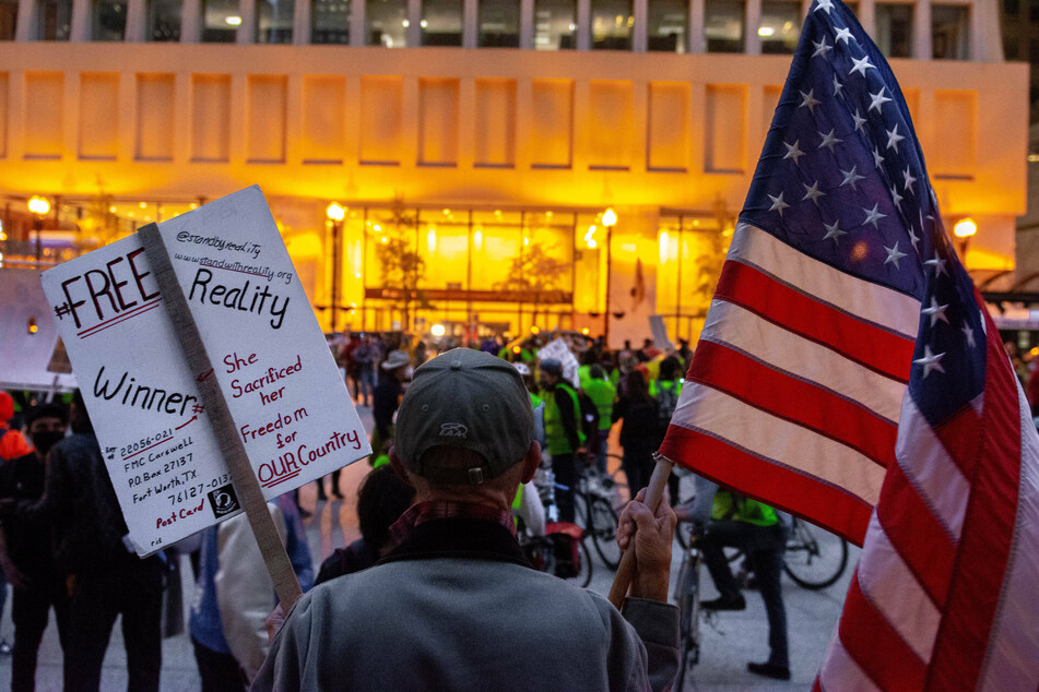 A protester holding a sign calling for the release of Reality Winner at Daley Plaza in Chicago in 2020.