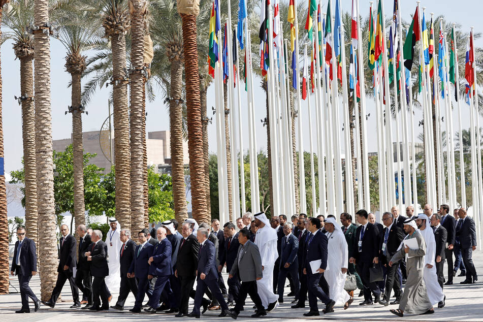 Officials walk to pose for a family photo during COP28 in Dubai, United Arab Emirates, on December 1, 2023.