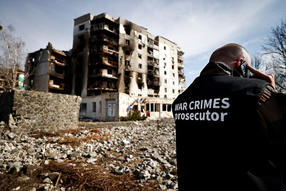 A war crimes prosecutor speaking on the phone in Borodyanka, where Russia is suspected to have committed atrocities.