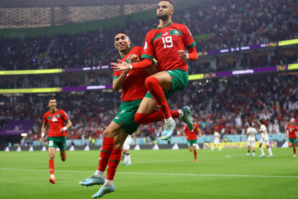 Morocco's Youssef En-Nesyri celebrates with Achraf Hakimi after scoring their first goal.