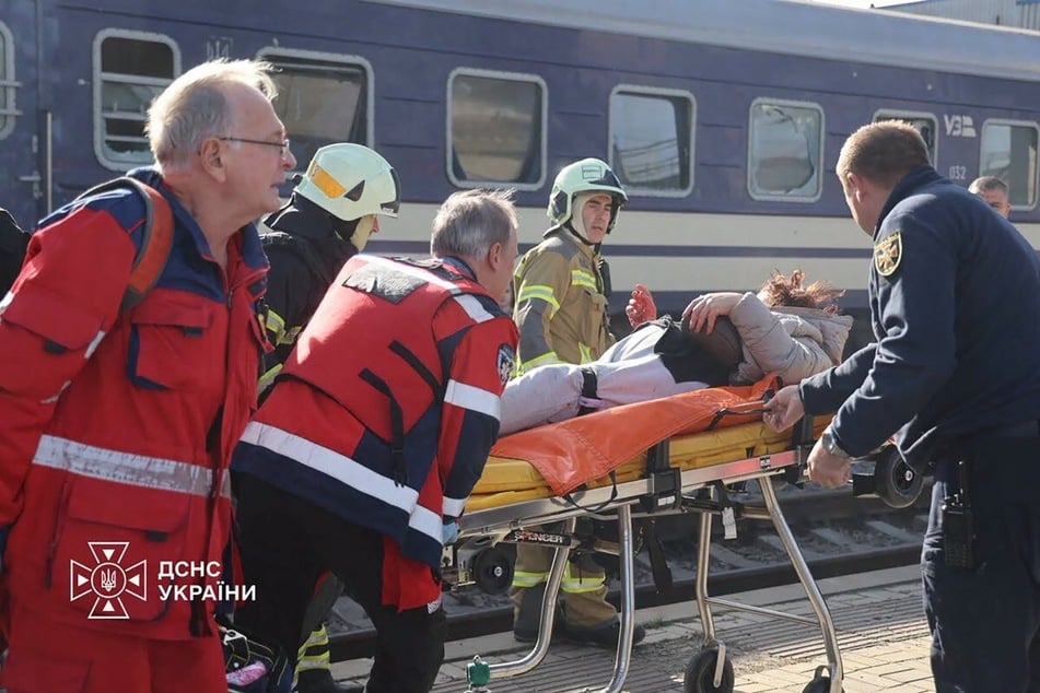 Ukrainian rescuers carry an injured person on a stretcher following an alleged drone attack by Russia on the train station in Dnipro. At least 13 people were killed in the attack, Ukrainian authorities said on October 29, 2026.
