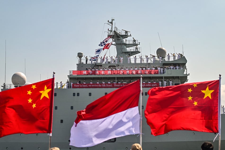 Crew members of Chinese navy ship Qi Liguang wave as their ship docks at Tanjung Perak Port in Surabaya, Indonesia, on August 2.