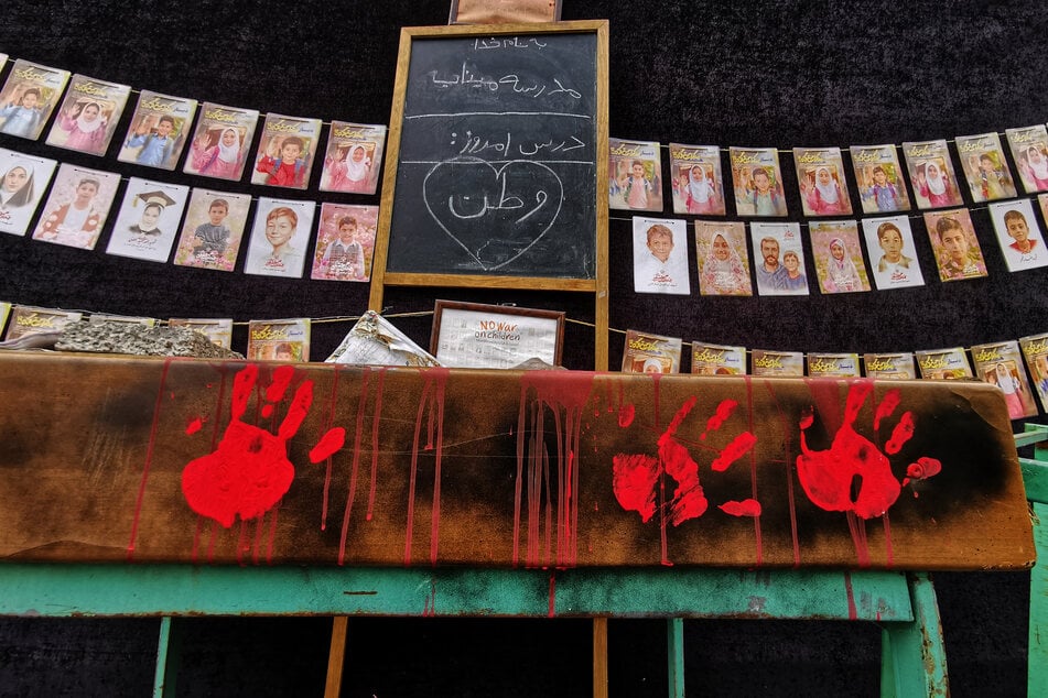 Images of children killed in a missile strike on a school in Minab, Iran, are strung along the wall of a mosque in Tehran on April 25, 2026.