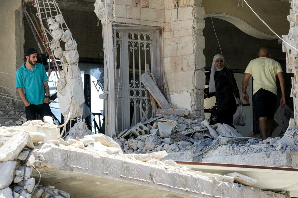 People inspect the ruins of a destroyed building in the village of Deir Qanoun al-Nahr in southern Lebanon on June 16, 2026.