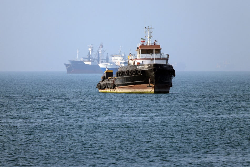 The Iran-flagged tugboat Basim sails near a ship anchored in the Strait of Hormuz off Bandar Abbas in southern Iran on May 4, 2026.