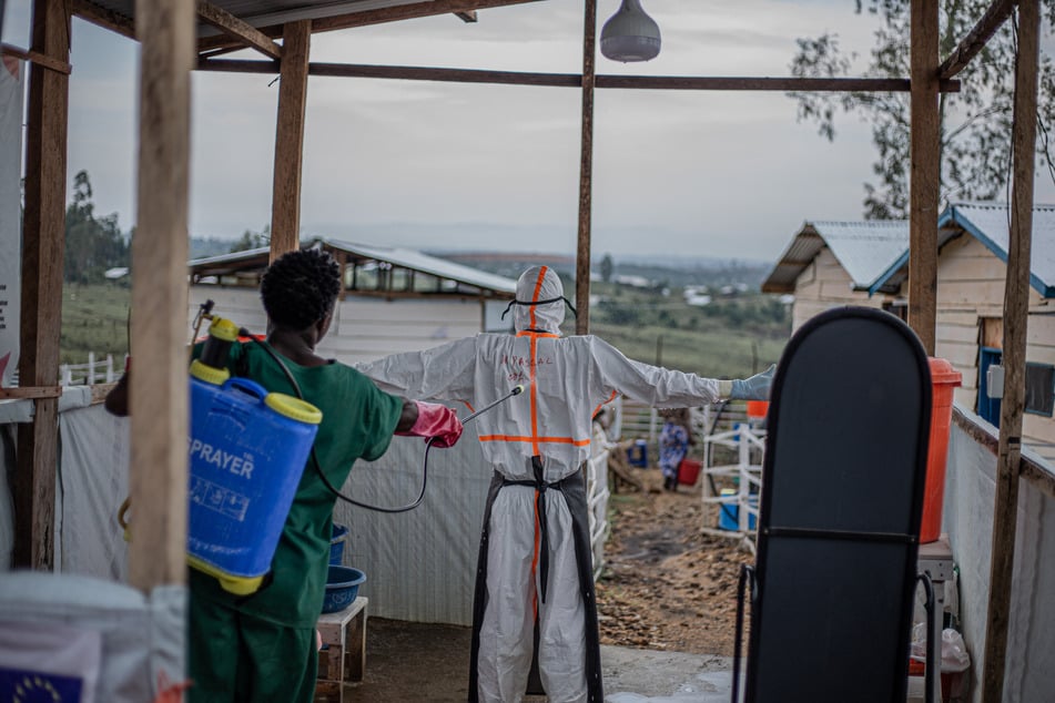 A hygiene specialist decontaminates a doctor leaving the patient care unit of the Rwampara Ebola Treatment Center (ETC) in Bunia, Ituri, in the east of the Democratic Republic of Congo on Wednesday.