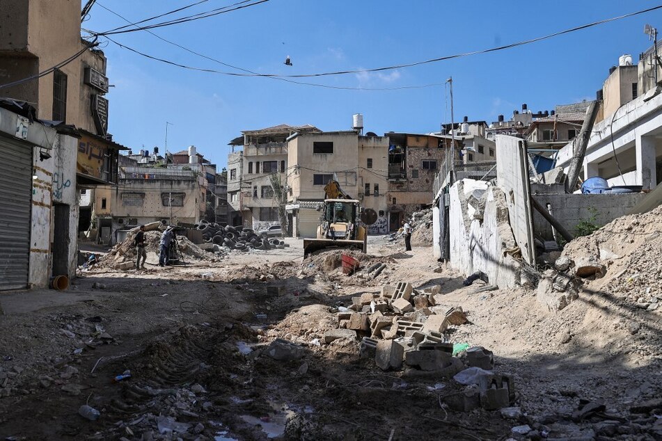 A bulldozer clears rubble from a road destroyed in Israeli raids at the Nur Shams refugee camp near Tulkarem in the occupied West Bank.