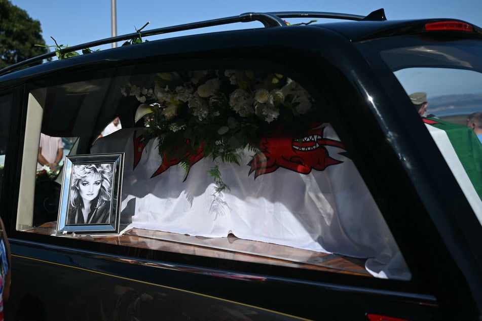 A hearse carrying the coffin of Bonnie Tyler and a photo of the late singer are driven through Mumbles, Wales, on August 15, 2026.