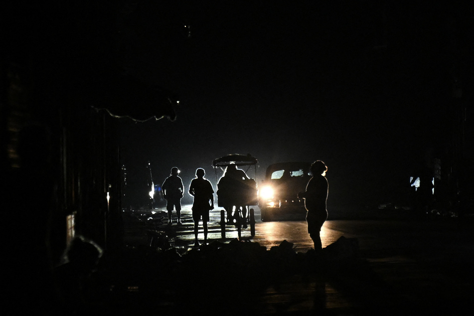 People walk along a street during a nationwide blackout in Havana, Cuba, on July 10, 2026.