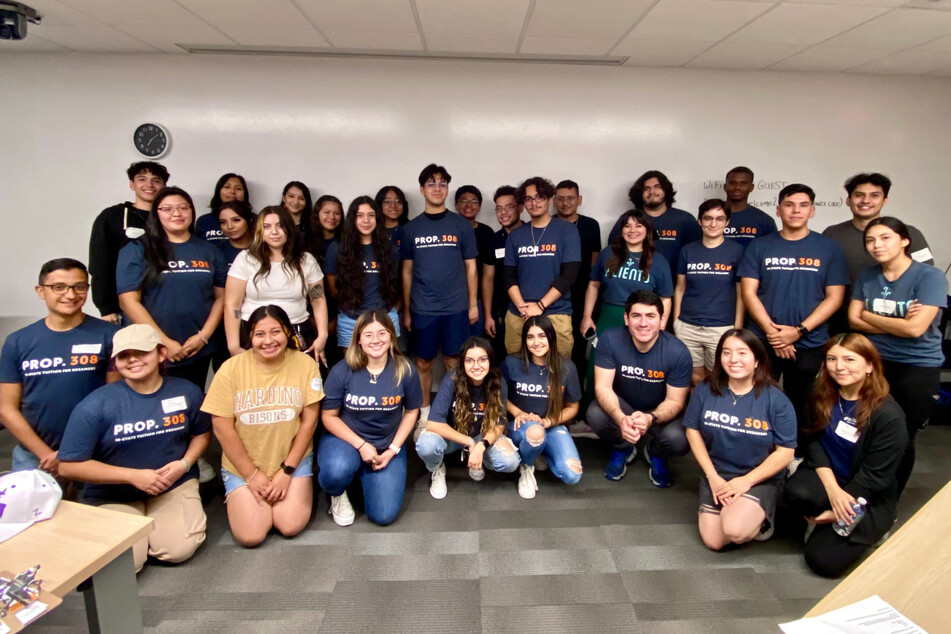 Immigrants' rights activists with Aliento pose together as votes are counted for Proposition 308 in Arizona.