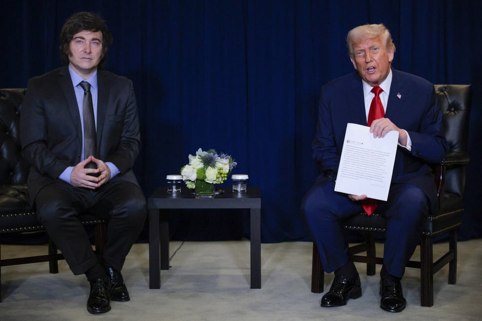 US President Donald Trump (r.) holds a printout of his social media post as he speaks with President of Argentina Javier Milei during a bilateral meeting at the 80th session of the UN General Assembly on September 23, 2025, in New York City.
