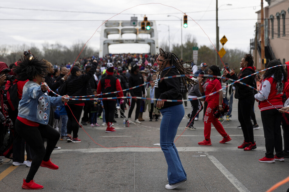 People jump rope in front of the Edmund Pettus Bridge during the commencement of the 60th anniversary of "Bloody Sunday" in Selma, Alabama.