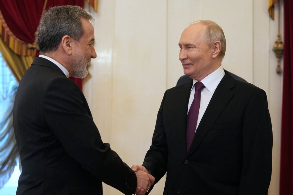 Russian President Vladimir Putin (r) shakes hands with Iranian Foreign Minister Abbas Araghchi (l) during their meeting at the Boris Yeltsin Presidential Library in Saint Petersburg on April 27, 2026.