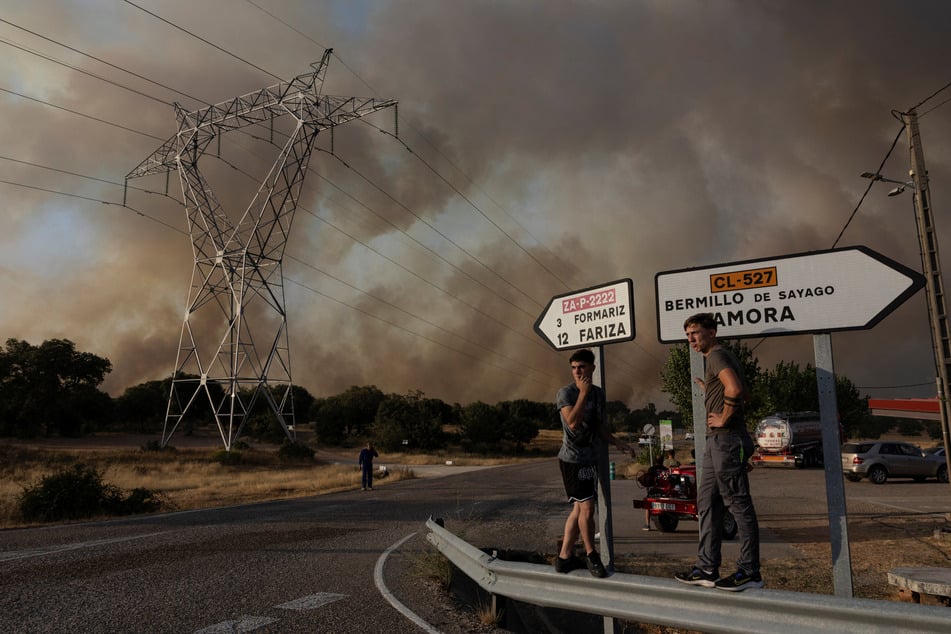 Locals watch near Formariz during a wildfire in Zamora province, Spain, on July 29, 2026.