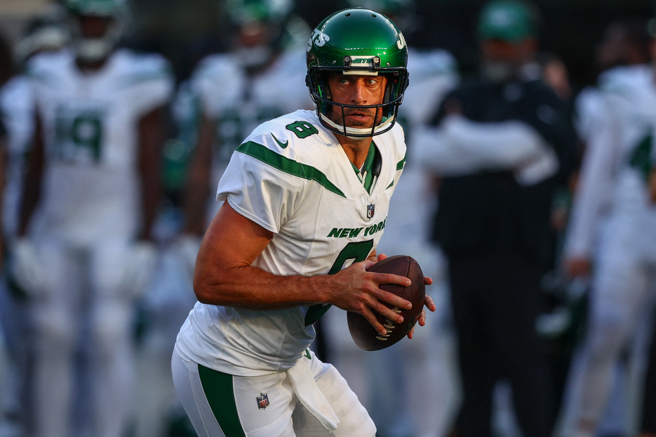 New York Jets quarterback Aaron Rodgers runs with the ball against the New York Giants during the first half at MetLife Stadium.