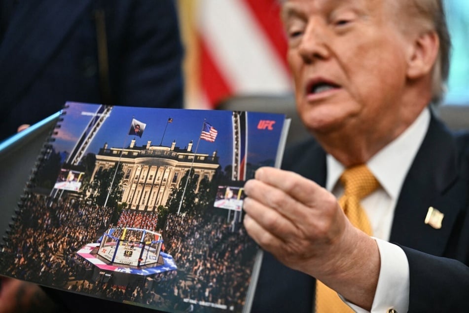 President Donald Trump shows a rendering of the upcoming "UFC Freedom 250" event as he speaks in the Oval Office of the White House on May 6, 2026, in Washington, DC.