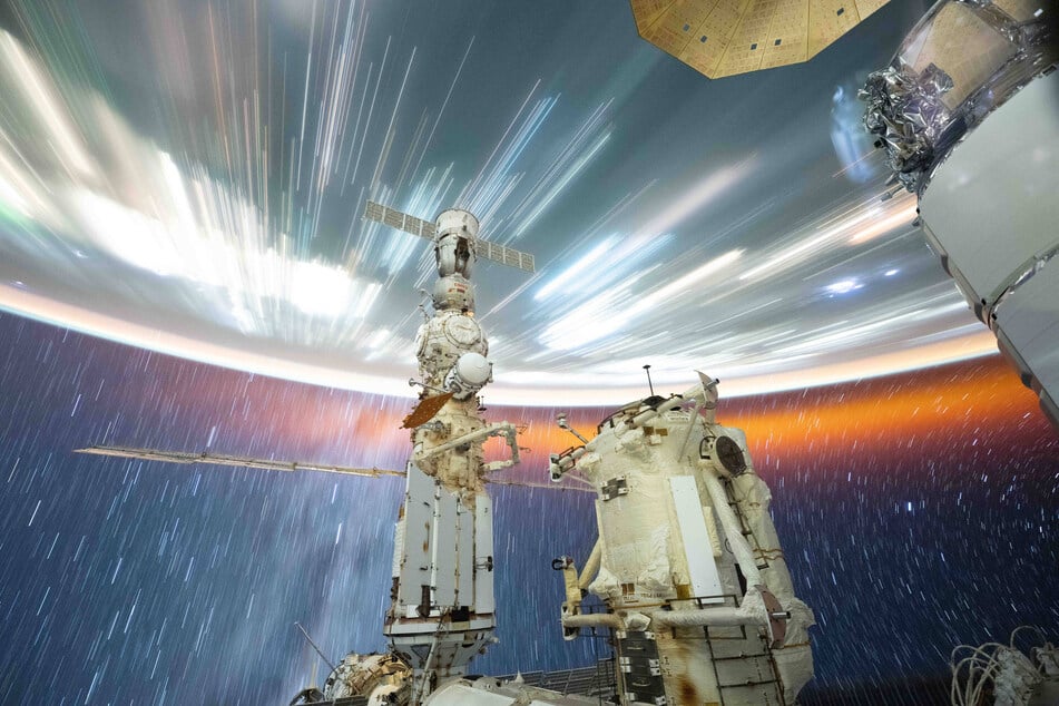 A long exposure photograph taken with a camera programmed for high sensitivity shows star trails and streaks of city lights as the International Space Station orbits 258 miles above the South China Sea at a speed of 17,150 miles per hour.