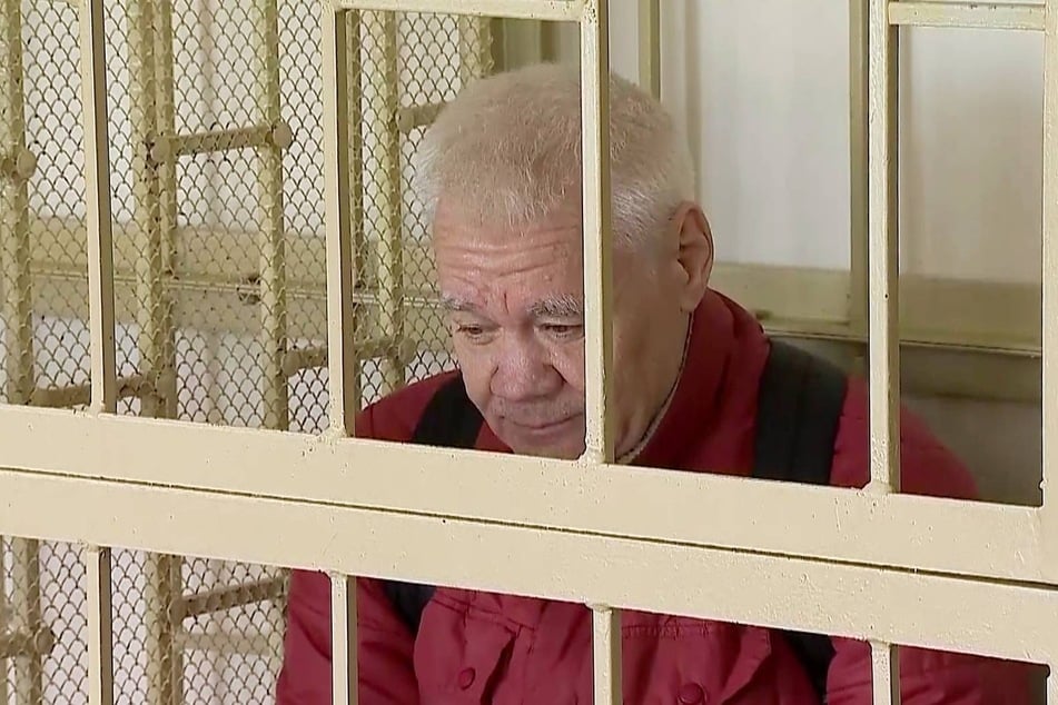 Robert Shonov, accused of confidential cooperation with a foreign state, sits inside a defendant's cage during a verdict hearing at the Primorsky Regional Court in Vladivostok, Russia.