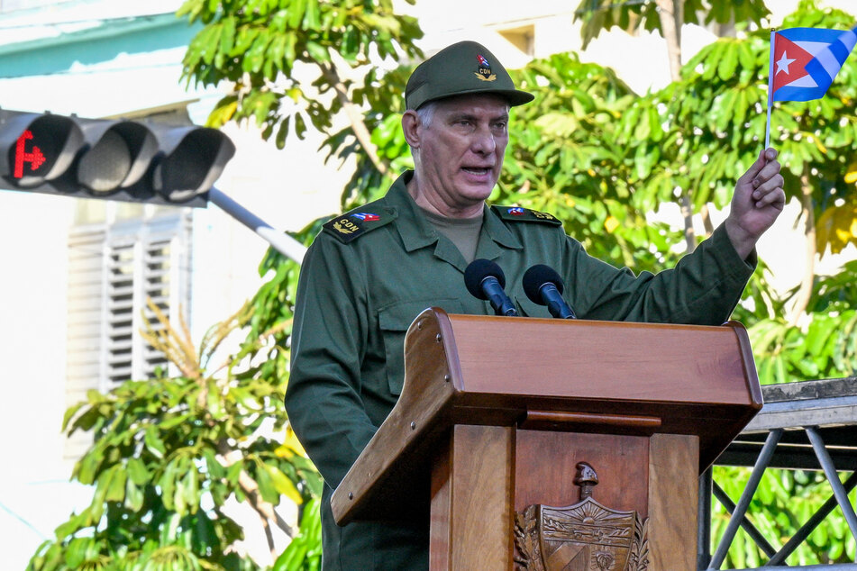 Cuba's President Miguel Diaz-Canel waves a national flag during celebrations marking the victory on the 65th anniversary of the Bay of Pigs invasion and the declaration of the socialist character of the Cuban Revolution in Havana on April 16, 2026.
