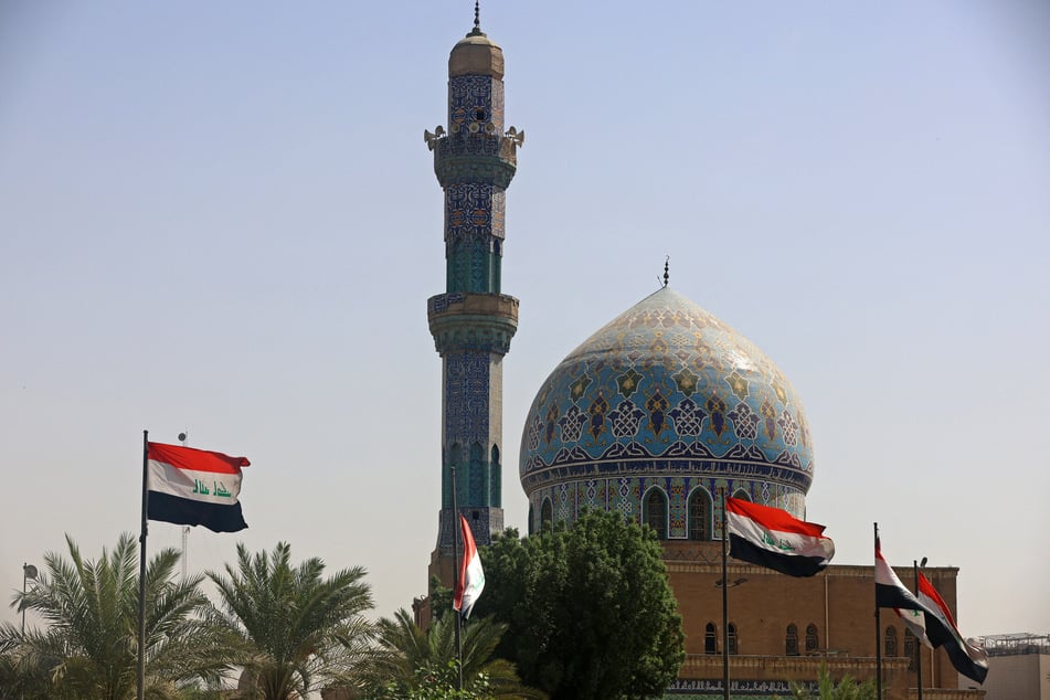 Iraqi flags flutter in front of a mosque in Baghdad on September 2026.