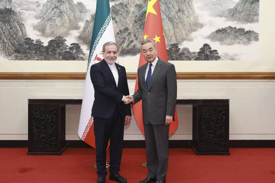Chinese Foreign Minister Wang Yi (r) reiterated Beijing's commitment to Tehran during a meeting with Iranian Foreign Affairs Minister Abbas Araghchi in Beijing on September 16.