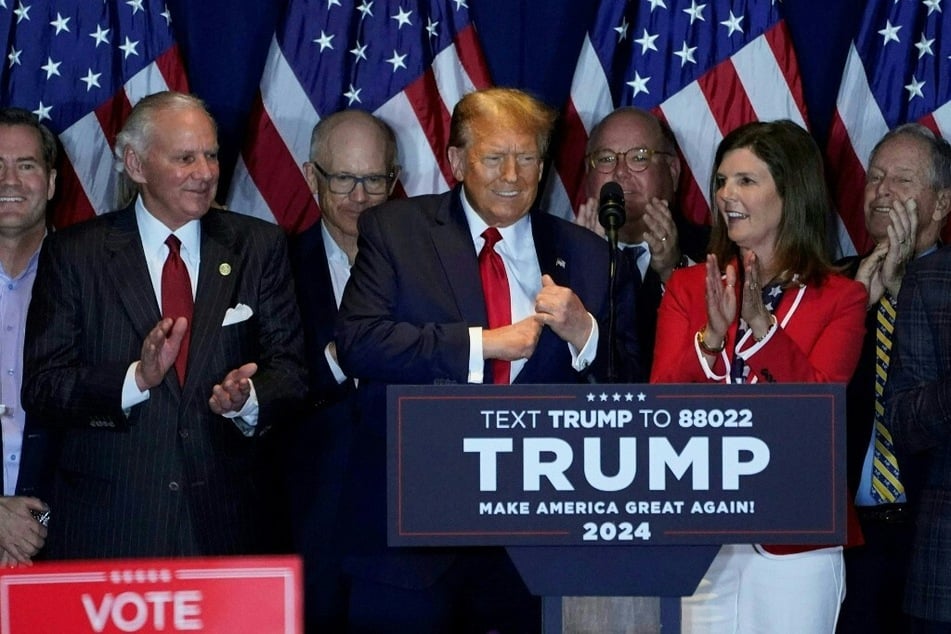 Former president and 2024 Republican frontrunner Donald Trump (c.) arrives to speak at an election night watch party in Columbia, South Carolina.