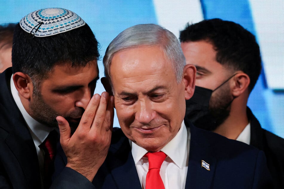 An aide speaks to Israeli Prime Minister Benjamin Netanyahu as he gives a statement following exit polls for Israel's national election on October 28, 2026.