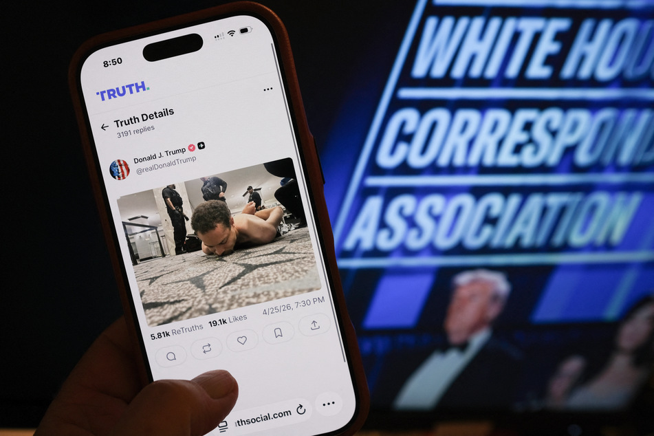 A phone with a Truth Social post by President Donald Trump displaying an image of the alleged suspect in a shooting incident at the White House Correspondents’ Dinner on the ground after being apprehended on April 25, 2026.