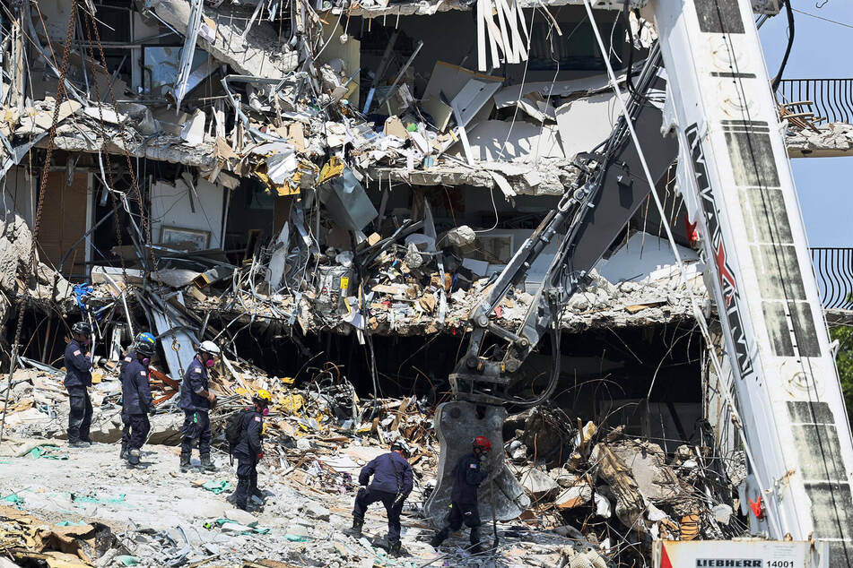Search and rescue personnel look for survivors through the rubble at the Champlain Towers.