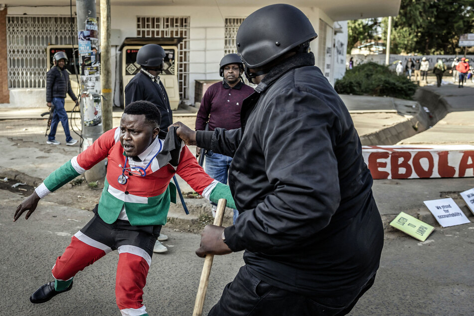 A protester reacts while being arrested by Kenyan police officers during a demonstration against a US-built Ebola quarantine center slated to begin operations at Laikipia Air Base in Nanyuki on June 9, 2026.