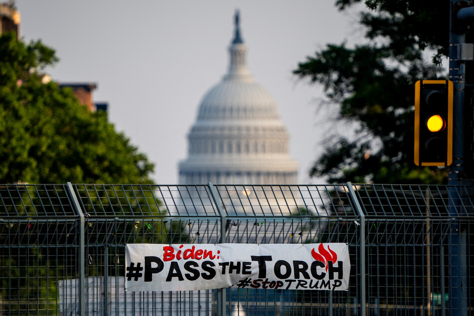 A sign that reads "Biden: #PassTheTorch, #StopTrump" is posted on the gate of an overpass with the dome of the US Capitol Building visible in the background on July 8, 2024 in Washington, DC.