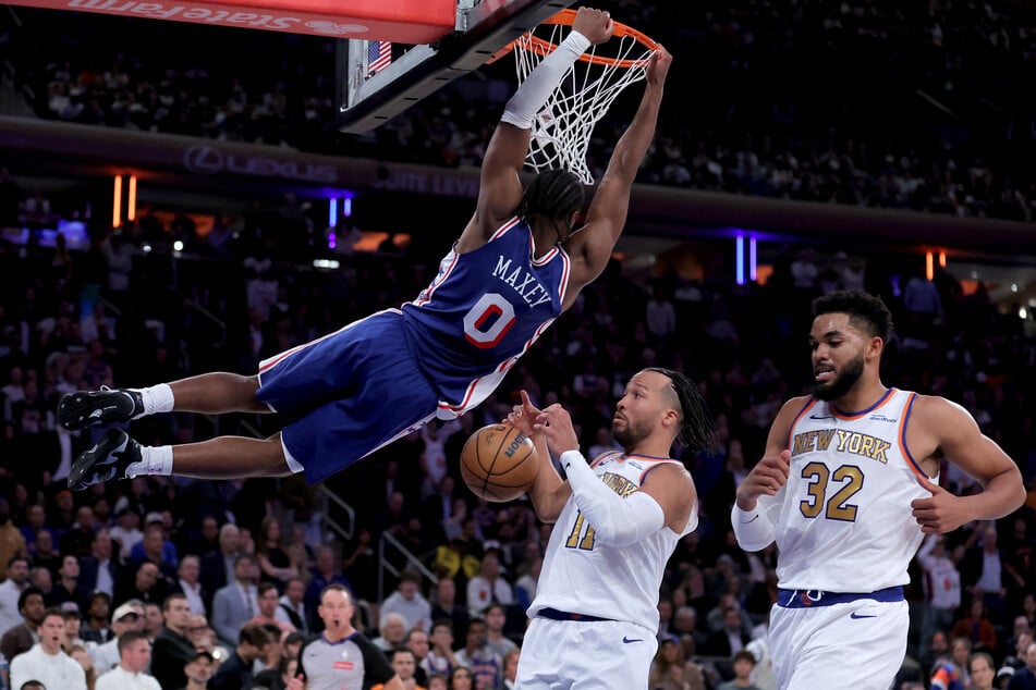 Philadelphia 76ers guard Tyrese Maxey hangs on the rim after a dunk against New York Knicks guard Jalen Brunson and center Karl-Anthony Towns during the fourth quarter at Madison Square Garden.
