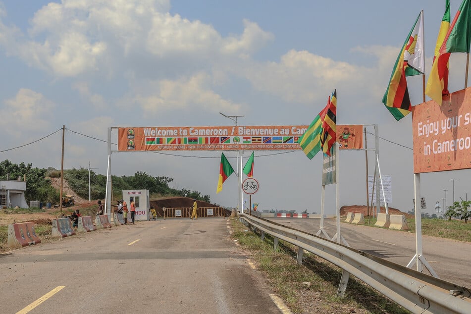 An aerial banner reading "Welcome to Cameroon" and flags of different countries are pictured at the exit of Yaoundé Nsimalen airport.